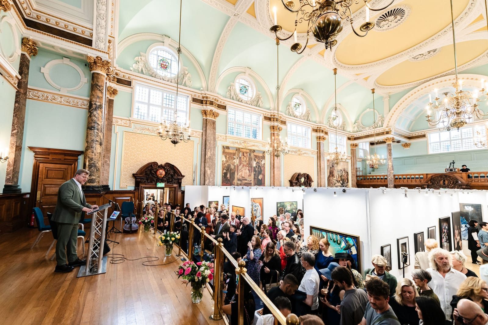 An audience seated in the main hall for the awards ceremony, beneath the gilded ceiling.