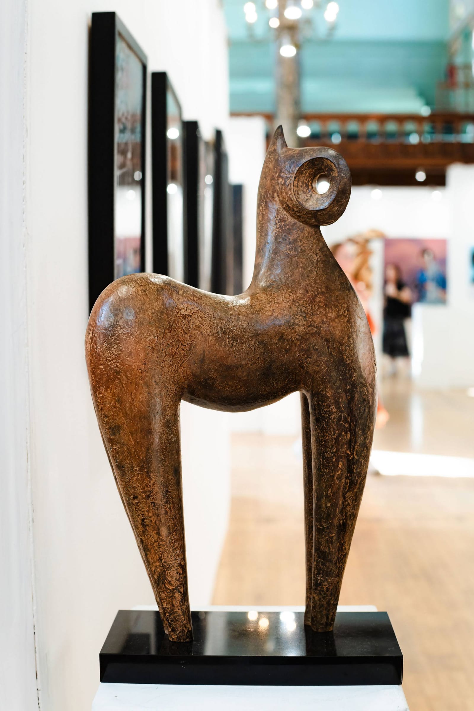 A bronze horse sculpture on a plinth in the exhibition hall.