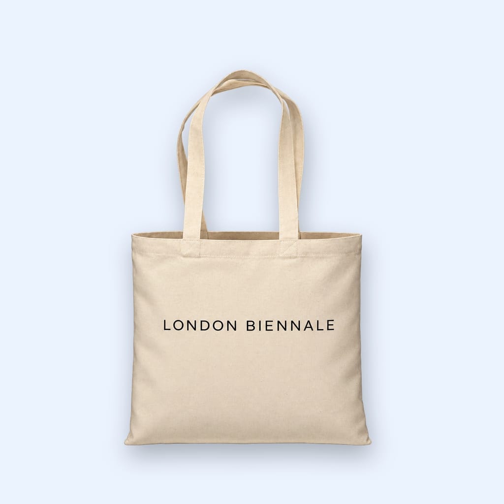 A natural cotton tote bag printed London Biennale, against a pale blue ground.