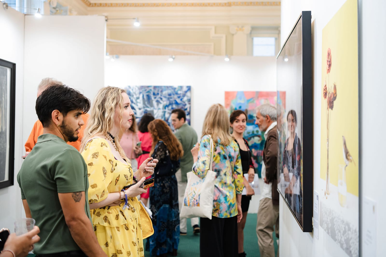 The private view in full swing: guests gathered in front of large hung paintings, the exhibition walls busy from end to end.