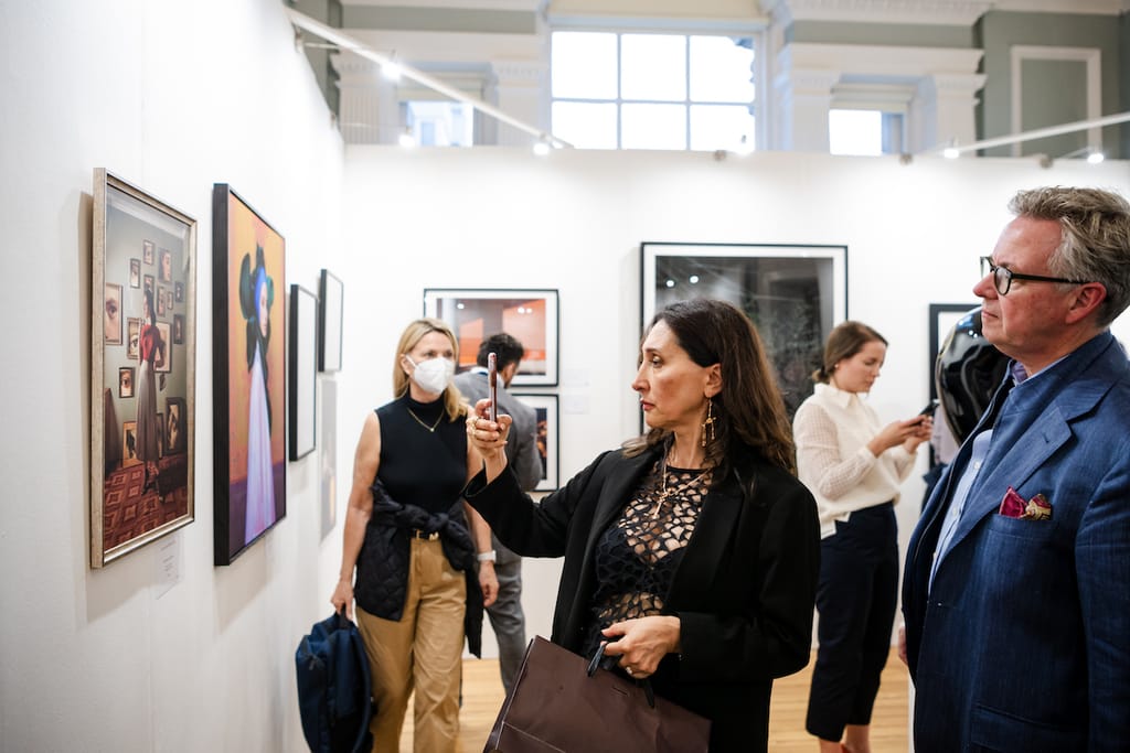 A visitor photographing a work at the exhibition.
